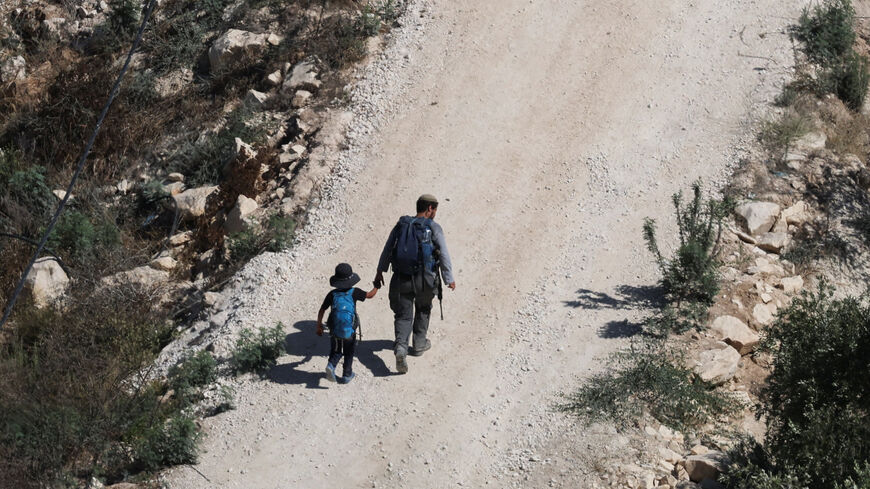 Israeli settlers approach the Palestinian village of Tal in the Israeli-occupied West Bank, July 31, 2026. REUTERS/Ammar Awad