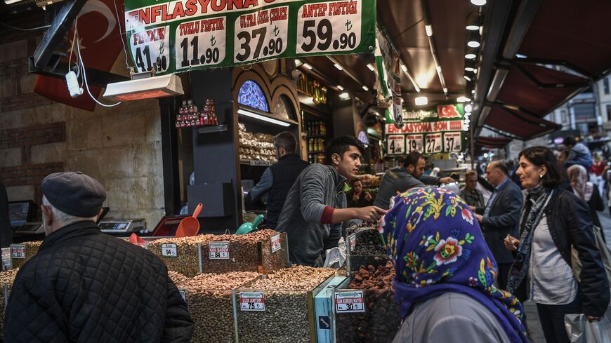 Vendors sell dry food as people shop by a banner reading " No to Inflation" near the New Mosque area in Istanbul's Eminonu district on Nov. 6, 2018. 