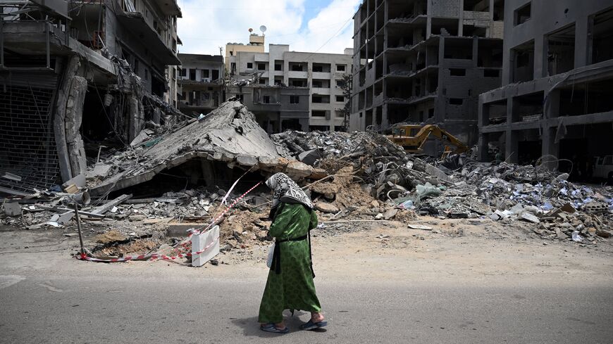 A woman walks past flattened building as workers remove the rubble from the site of an earlier Israeli military strike on a neighbourhood in the southern Lebanese coastal city of Tyre on June 23, 2026. On June 22, 2026, mediators Pakistan and Qatar said that Tehran and Washington had agreed to set up a "de-confliction cell" to limit flare-ups in Lebanon following talks in Switzerland on ending the wider Middle East war, which Tehran has linked to halting the parallel conflict in Lebanon. (Photo by Joseph EI