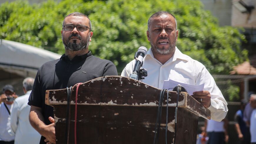Government Media Office Director Ismail Thawabteh (R) and Hamas spokesperson Hazem Qassem (L) speak at a press conference.