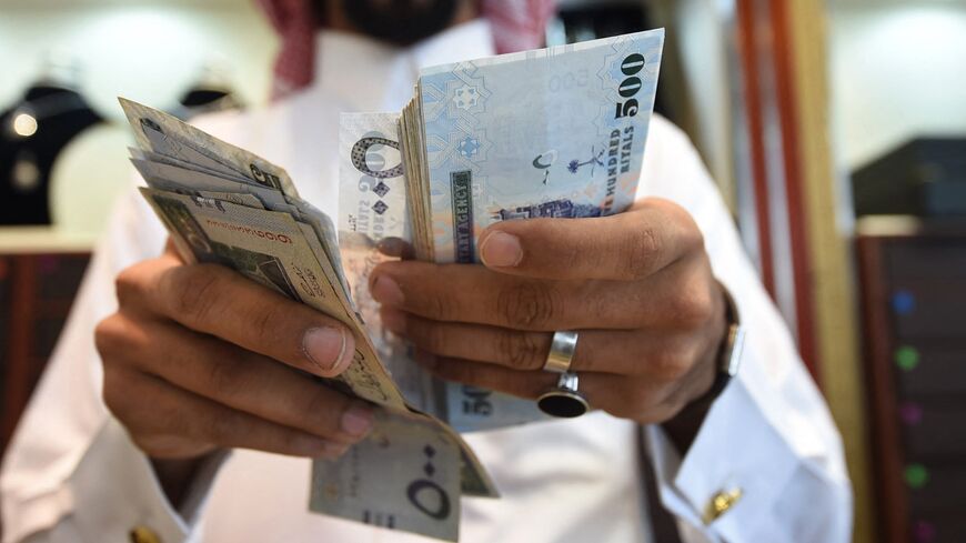 A man counts Saudi riyal banknotes in the capital, Riyadh, Oct. 3, 2016.
