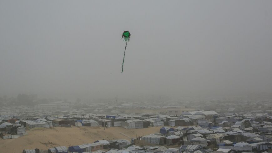 A kite flies over tents and makeshift shelters at a camp for displaced Palestinians in Khan Yunis, in the southern Gaza in February 2026
