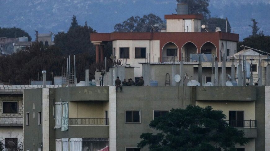 Israeli soldiers stand on the roof of a residential building in the Lebanese village of Zawtar al-Charkiyah