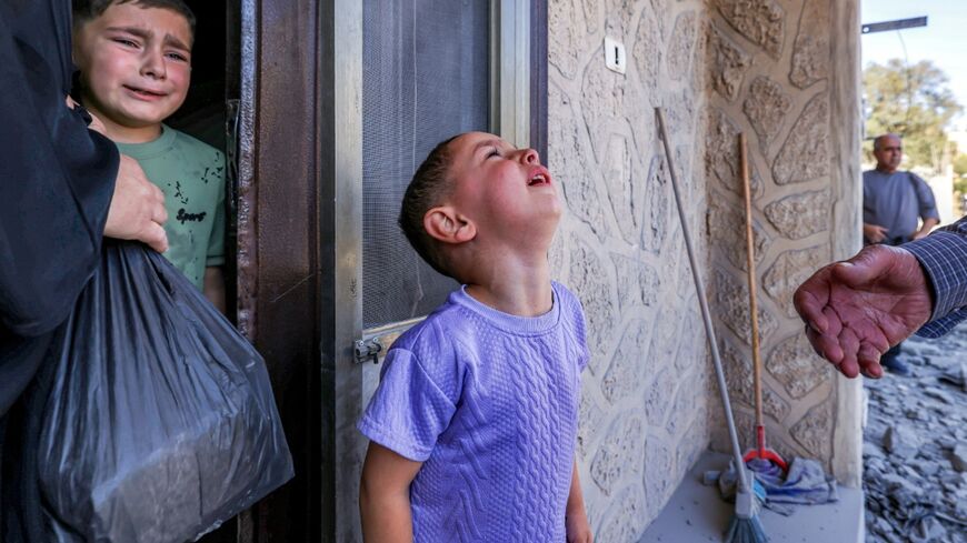 Child relatives of Palestinian Farouk Ramadan, who was involved and killed in clashes with Israeli settlers on July 24, watch after the controlled-demolition of his former apartment the village of Tell in the occupied West Bank