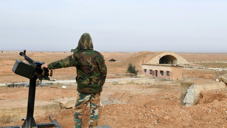 A member of Syrian government forces stands guard at the Abu Duhur military air base area in Idlib province in 2018