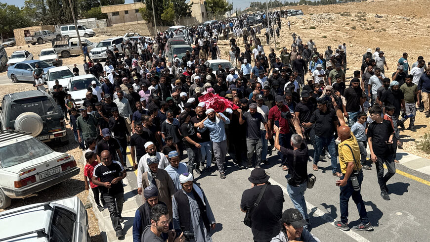 FILE PHOTO: Mourners carry the body of well-known Palestinian activist Owdeh Hathaleen, who, according to people who said they witnessed the shooting, was shot and killed in the village of Umm al-Khair by Israeli settler last week, during his funeral near the city of Hebron in the Israeli-occupied West Bank August 7, 2025. REUTERS/Yosri Aljamal/ File Photo