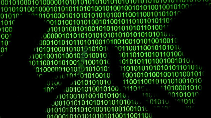 Silhouettes of laptop users are seen next to a screen projection of binary code are seen in this picture illustration taken March 28, 2018.  REUTERS/Dado Ruvic/Illustration
