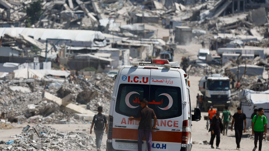 A person stands on the back of an ambulance at a site destroyed during the Israeli offensive, in Beit Lahiya, in the northern Gaza Strip, August 18, 2026. REUTERS/Mahmoud Issa