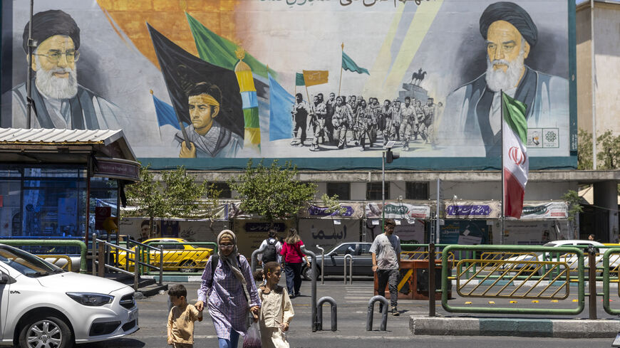 Pedestrians walk past a billboard depicting Iran's late Supreme Leaders Ayatollah Ruhollah Khomeini and Ayatollah Ali Khamenei, Tehran, Iran, June 15, 2026.