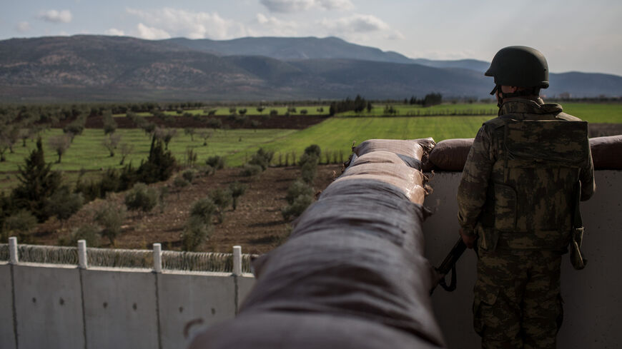A Turkish soldier from the 1st Border Regiment Command looks out over the border wall to Syria during alert drills at a military outpost on the Turkey/Syria border on March 2, 2017 in Kilis, Turkey. 