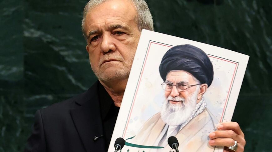 Iran's President Masoud Pezeshkian holds a picture of Ali Khamenei, former supreme leader of Iran, during his address at the United Nations General Assembly
