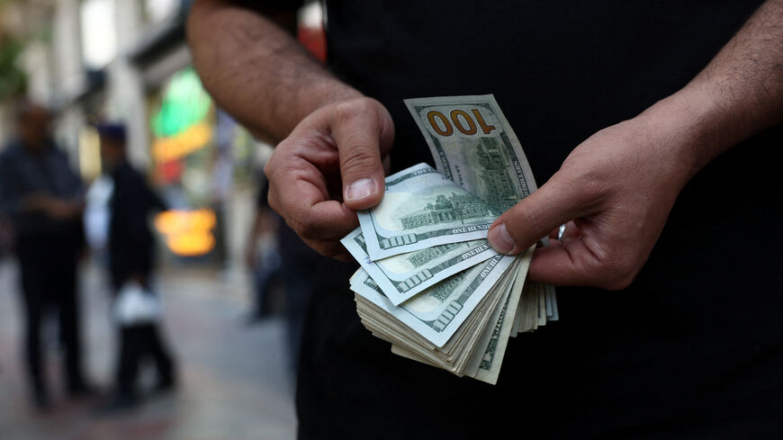 A currency dealer holds one-hundred-dollar bills in Tehran, Iran, May 2, 2026. Majid Asgaripour/WANA (West Asia News Agency) via REUTERS