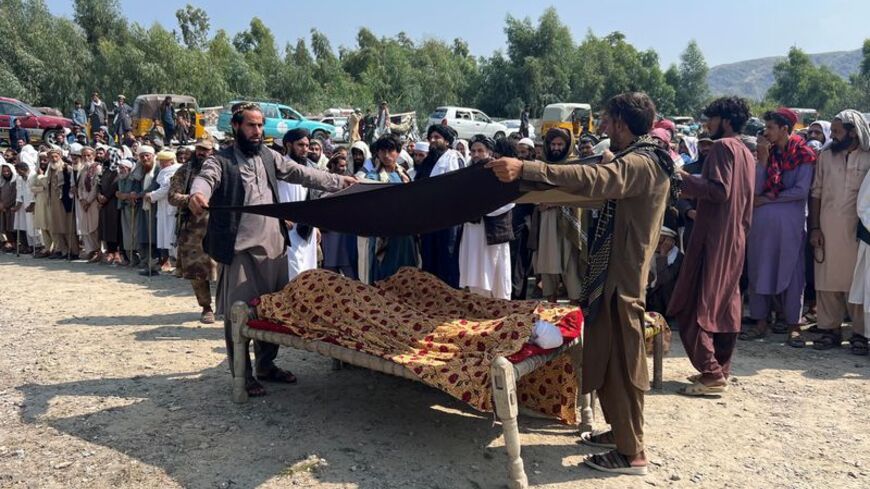 People place a black cloth over the bodies of victims killed in what the Taliban said was a Pakistani airstrike, in Kunar province