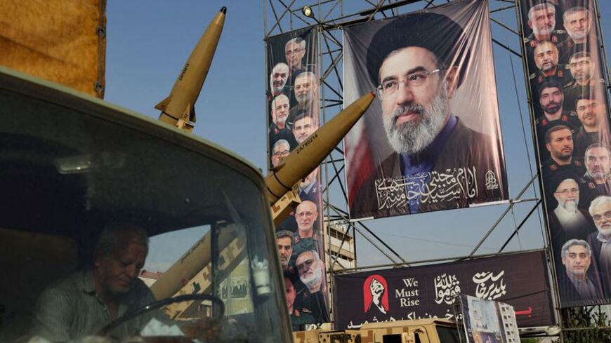 Iranian missiles are displayed next to a banner with a picture of Iran's Supreme Leader, Mojtaba Khamenei, on a street in Tehran