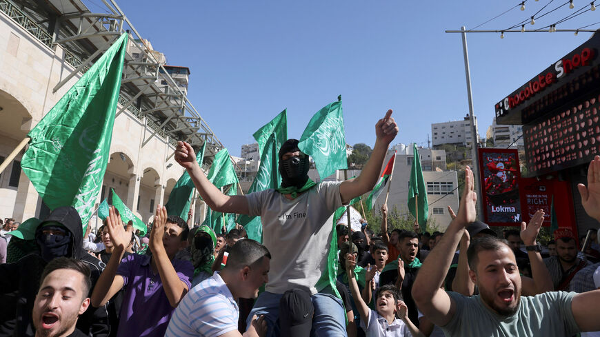 Palestinians hold up the green Hamas flag during a protest by supporters of both the Fatah and Hamas movements, as they rally in support of the Palestinian people following Friday noon prayers in Hebron, occupied West Bank, Nov. 3, 2023.