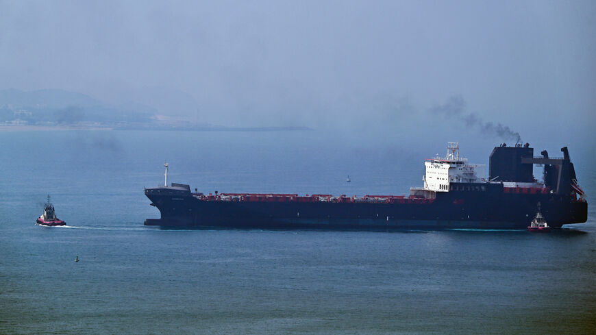 A tugboat guides a ship at the Khor Fakkan Container Terminal, the only natural deep-sea port in the region and one of the major container ports in Sharjah Emirate, along the Gulf of Oman on July 14, 2026.