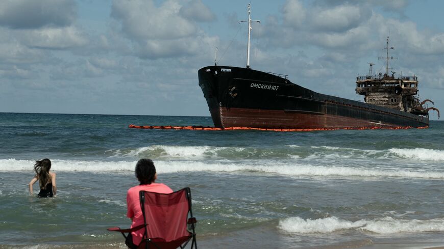 People swim next to the Russian-flagged cargo ship OMSKIY-107, which was attacked off the Black Sea coast and eventually ran aground off the shore of the Sile district, Istanbul, Sept. 3, 2026.