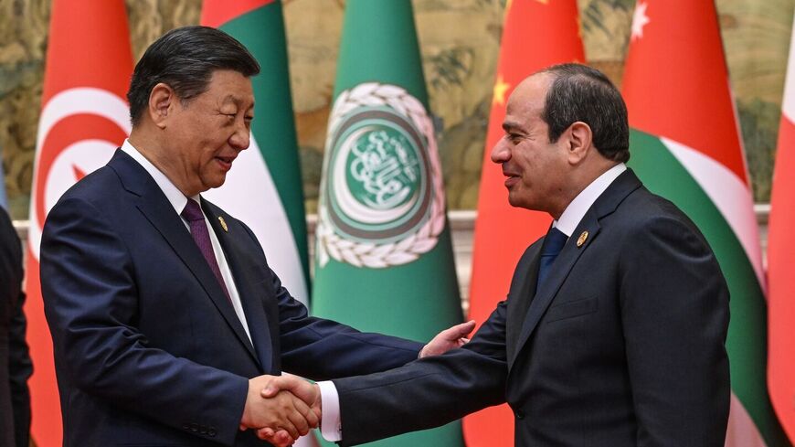 Chinese President Xi Jinping (L) shakes hands with Egypt's President Abdel Fattah al-Sisi on 