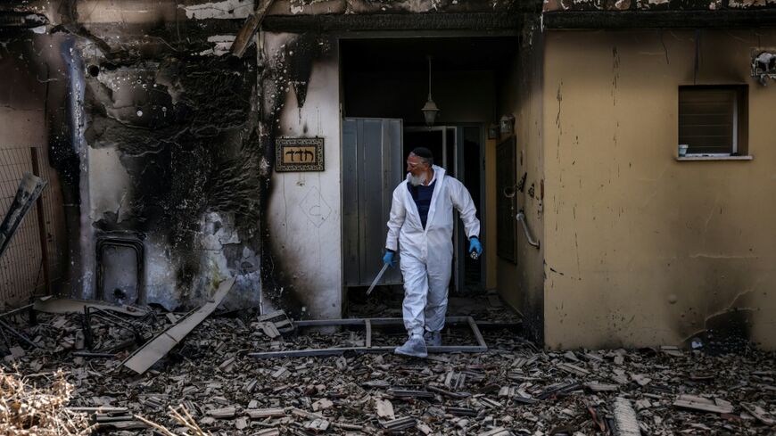 A volunteer of the Zaka Israeli ultra-Orthodox Jewish emergency response team searches through the debris in Kibbutz Beeri near the border with Gaza on October 20, 2023, in the aftermath of an attack by Palestinian militants on October 7
