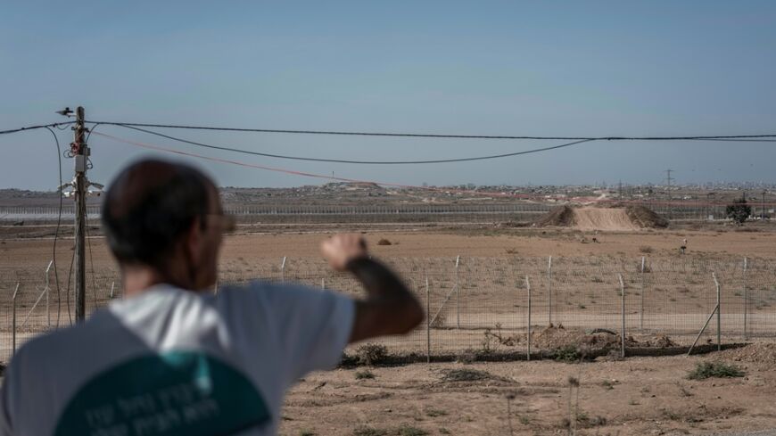 Danny Rahamin, a resident of the Israeli kibbutz of Nahal Oz, points at the adjacent Gaza border