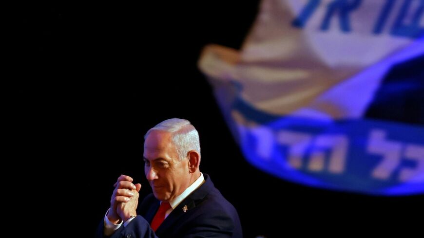 Israel's Prime Minister Benjamin Netanyahu gestures to his supporters at the election night rally after the first exit polls were announced, in Jerusalem