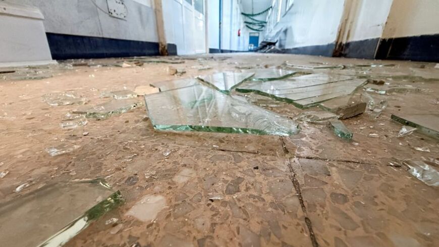 Pieces of shattered glass are scattered across the floor of a hospital following an airstrike on a nearby building in Sanaa