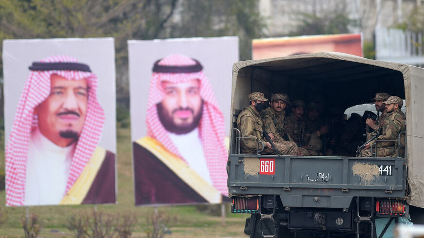 Pakistani soldiers (R) patrol on a street next to welcoming posters of Saudi Arabian Crown Prince Mohammed bin Salman in Islamabad on Feb. 17, 2019.