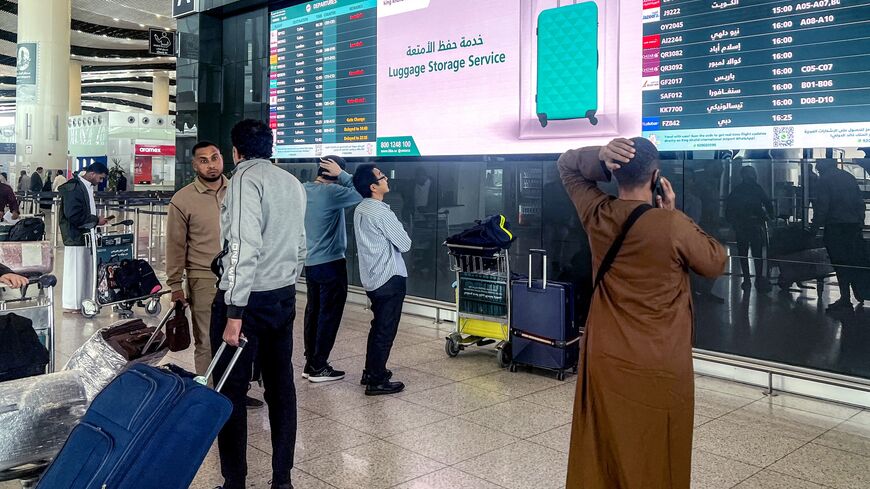 Travelers consult the departures screens at the terminal at King Khalid International Airport in Riyadh, on March 10, 2026.