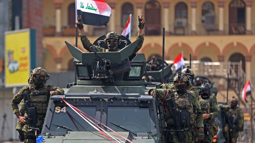 A member of the Iraqi security forces flashes the victory sign during a military parade