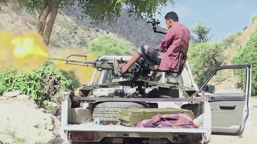 a member of the Saudi-backed Yemeni government forces firing a machine gun mounted on a pick-up truck