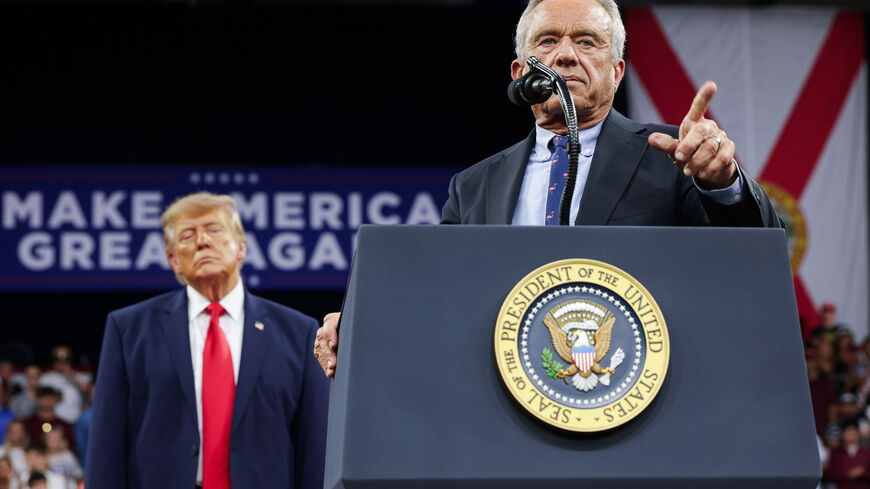 FORT MYERS, FLORIDA - OCTOBER 23: U.S. President Donald Trump (L) listens as U.S. Secretary of Health and Human Services Robert F. Kennedy Jr. speaks during an election rally at Alico Arena on the Florida Gulf Coast University campus on October 23, 2026 in Fort Myers, Florida. President Trump traveled to Florida to rally for local Republican candidates ahead of next week's midterm elections. (Photo by Alex Wong/Getty Images)