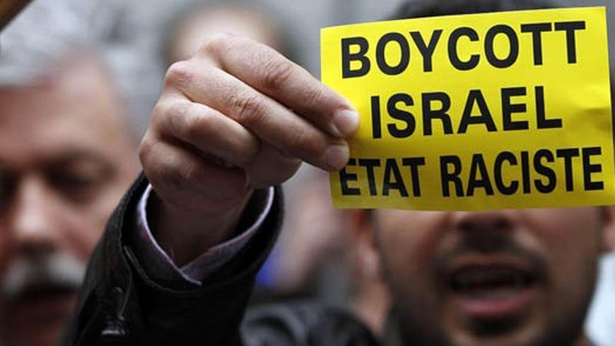 A demonstrator displays a sign reading "Boycott Israel, racist state" outside the Belgian foreign affairs building during a protest in Brussels May 31, 2010. Israel's storming of a Gaza-bound aid flotilla set off a diplomatic furore, drawing criticism from friends and foes alike and straining ties with regional ally Turkey, which called off planned joint military exercises. REUTERS/Francois Lenoir (BELGIUM - Tags: CIVIL UNREST POLITICS IMAGES OF THE DAY)
