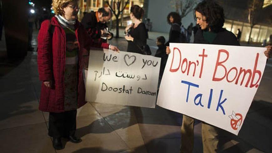 Israelis hold placards as they protest, against a possible attack of Iran's nuclear facilities, in Tel Aviv March 24, 2012. Hundreds of protesters marched in Tel Aviv on Saturday evening with signs calling against a possible war. REUTERS/Nir Elias (ISRAEL - Tags: POLITICS CIVIL UNREST)