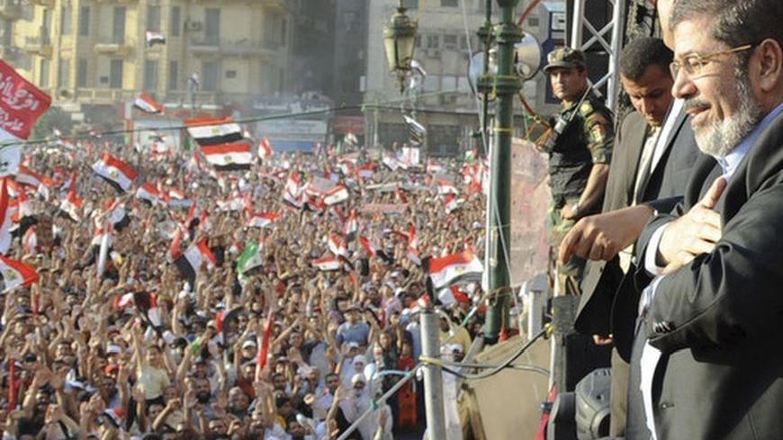Egypt's Islamist President-elect Mohamed Mursi looks at the crowd that had gathered for his speech in Cairo's Tahrir Square June 29, 2012. Mursi took an informal oath of office on Friday before tens of thousands of supporters in Cairo's Tahrir Square, in a slap at the generals trying to limit his power. REUTERS/Egyptian Presidency/Handout (EGYPT - Tags: POLITICS) FOR EDITORIAL USE ONLY. NOT FOR SALE FOR MARKETING OR ADVERTISING CAMPAIGNS. THIS IMAGE HAS BEEN SUPPLIED BY A THIRD PARTY. IT IS DISTRIBUTED, EXA