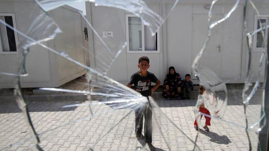 A window, broken by a stray bullet from clashes between the Syrian army and the rebels on Monday, is seen at a refugee camp named "Container City" in the province of Kilis April 13, 2012. Most of the refugees in Turkey are located in the provinces of Gaziantep and Hatay. Authorities have also erected a container city in the province of Kilis where 9,000 people are staying. So many refugees have fled the violence in Syria that Turkey has begun accepting international aid to help share the cost of the caring 