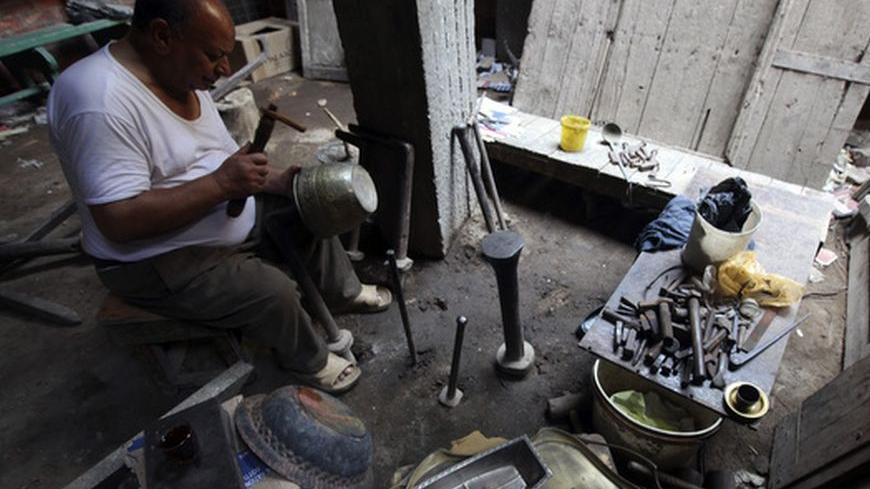 Hag Mohamed ,65, works at his copper workshop at the market of Khan el-Khalili in the old city of Cairo June 15, 2012. Activists called for a protest on Friday and Islamists warned that the gains of the revolt that toppled Hosni Mubarak could be wiped out after Egypt's supreme court dissolved parliament and ruled to keep his last premier in this weekend's presidential race. REUTERS/Amr Abdallah Dalsh  (EGYPT - Tags: POLITICS CIVIL UNREST ELECTIONS)