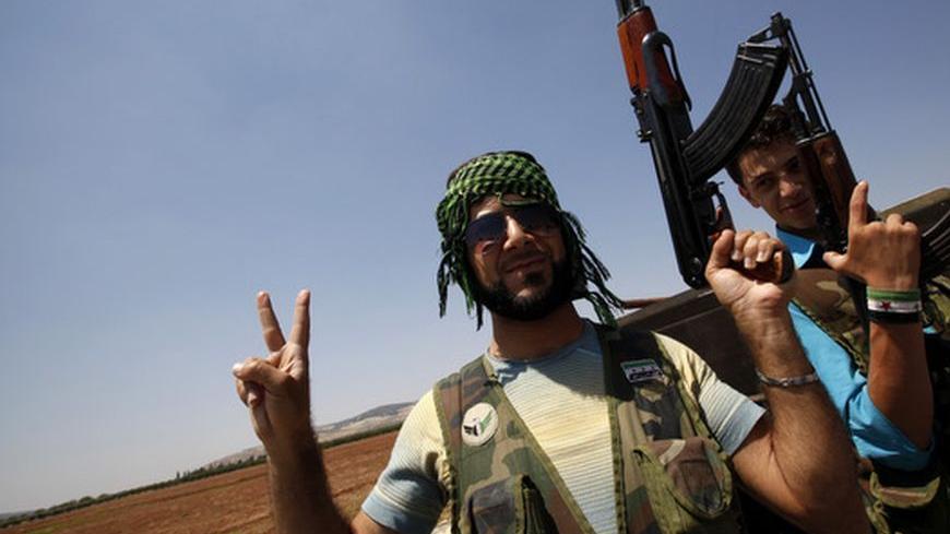 Free Syrian Army soldiers flash v-signs and raise their rifles in Azaz, north Syria July 25, 2012. REUTERS/Umit Bektas (SYRIA - Tags: POLITICS MILITARY CIVIL UNREST)