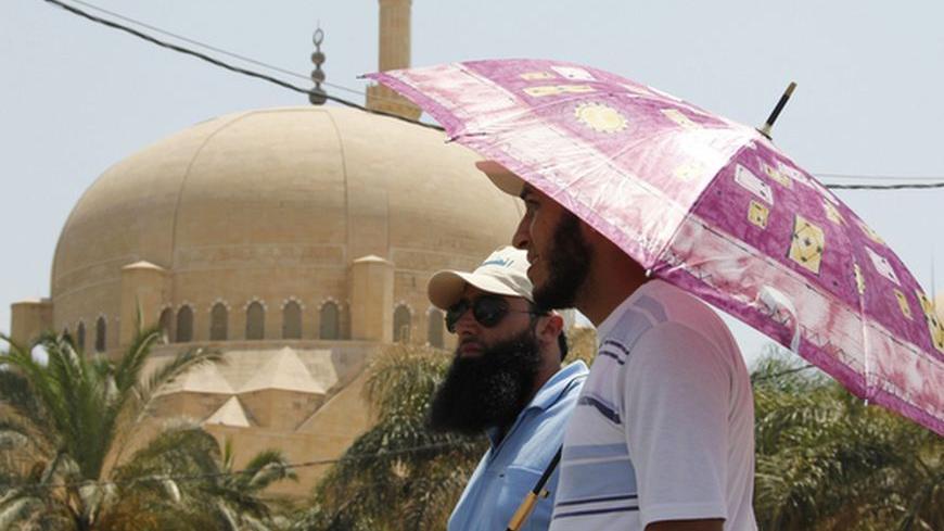 Supporters of Sunni Muslim Salafist leader Ahmad al-Assir stand under an an umbrella at an open-ended sit-in in Sidon, southern Lebanon, June 29, 2012. Lebanese Sunni Muslim Salafists are holding an open-ended sit-in  after their leader Sheikh Ahmad al-Aseer called on Lebanese armed parties - especially Shi'ite Hezbollah - to give up their arms and have the army and the security forces be the sole possessors of arms in the country. REUTERS/Ali Hashisho   (LEBANON - Tags: POLITICS CIVIL UNREST)