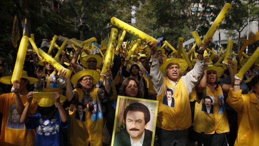 A woman holds a picture of Iranian resistance leader Massoud Rajavi as supporters of the main Iranian opposition, the Mujahedin-e Khalq, protest against Iranian President Mahmoud Ahmadinejad's visit to the U.N. outside the U.N. headquarters in New York September 22, 2011. REUTERS/Eduardo Munoz (UNITED STATES - Tags: POLITICS)