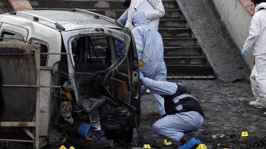 Police forensic officers inspect the scene of a bombing near police vehicles in Istanbul March 1, 2012. A remote control bomb injured 10 police officers on Thursday as their vehicle passed close to the Istanbul headquarters of Turkey's ruling AK Party, Turkish police said. Istanbul police chief Huseyin Capkin said the device was placed on a motorcycle and set off by remote control as a police vehicle drove past, near the AK Party building and the offices of a conservative business association.   REUTERS/Osm