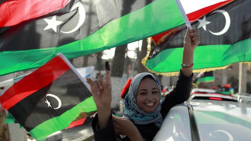 A woman celebrates on the streets after casting her vote during the National Assembly election in Tripoli's Martyrs square July 7, 2012. Crowds of joyful Libyans, some with tears in their eyes, parted with the legacy of Muammar Gaddafi on Saturday as they voted in the first free national election in 60 years. REUTERS/Zohra Bensemra (LIBYA - Tags: ELECTIONS POLITICS)