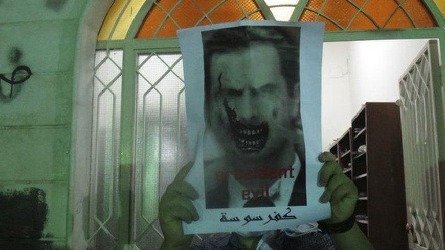 Demonstrators hold poster of Syria's President Bashar al-Assad at Kfr Suseh area in Damascus August 3, 2012. Picture taken August 3, 2012.  REUTERS/Shaam News Network/Handout  (SYRIA - Tags: POLITICS CIVIL UNREST) FOR EDITORIAL USE ONLY. NOT FOR SALE FOR MARKETING OR ADVERTISING CAMPAIGNS. THIS IMAGE HAS BEEN SUPPLIED BY A THIRD PARTY. IT IS DISTRIBUTED, EXACTLY AS RECEIVED BY REUTERS, AS A SERVICE TO CLIENTS