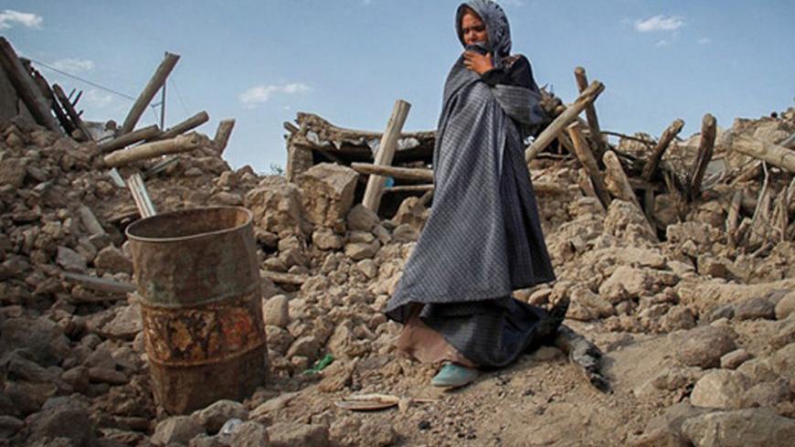 An earthquake victim stands near damaged houses in the earthquake-stricken town of Azerbaijan in Iran, August 13, 2012. Rescue workers in Iran on Tuesday recovered more bodies three days after two powerful earthquakes struck the northwest of the country, killing more than 300 people, but officials played down reports that casualty numbers may still sharply rise. Picture taken August 13, 2012. REUTERS/Farshid Tighehsaz/ISNA (IRAN - Tags: DISASTER) FOR EDITORIAL USE ONLY. NOT FOR SALE FOR MARKETING OR ADVERTI