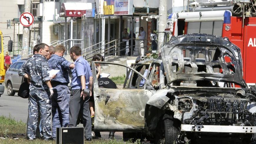 Russian investigators work near the scene of a car bomb blast in the city of Kazan July 19, 2012. The most senior Islamic official in Russia's largely Muslim Tatarstan region was wounded in a car bomb attack and his deputy was killed in a separate shooting on Thursday, law enforcement officials said.  REUTERS/Aleksey Nasyrov  (RUSSIA - Tags: CIVIL UNREST CRIME LAW RELIGION)
