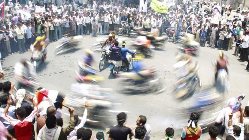 Anti-government protesters watch as fellow protesters ride motorcycles during a demonstration demanding the ouster of Yemen's President Ali Abdullah Saleh in the southern city of Taiz May 2, 2011. Yemeni activists urged street protesters on Monday not to raise banners of Osama bin Laden to avoid inviting a harsher crackdown on demonstrations seeking democratic change in the al Qaeda leader's ancestral homeland. REUTERS/Khaled Abdullah (YEMEN - Tags: POLITICS CIVIL UNREST IMAGES OF THE DAY)
