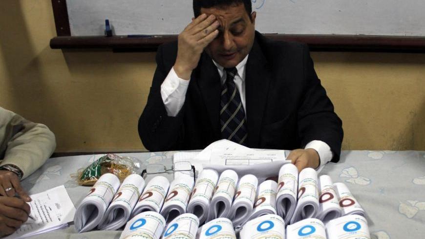 Supervising judge of El-Baheyya El-Burhaneyya polling station in Cairo's poor district of Sayyeda Zeinab fills the count forms after more than two hours of counting votes. Sunday Dec. 16, 2012.