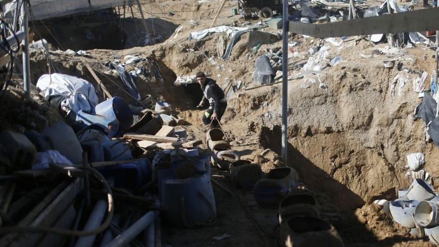 A Palestinian works at the entrance of a smuggling tunnel dug beneath the Egyptian-Gaza border in Rafah, in the southern Gaza Strip November 26, 2012. Knee-deep in craters carved out by Israeli air strikes, Palestinians wielded shovels and planks to reopen tunnels used to smuggle in goods from Egypt to Gaza, as international aid agencies raced to replenish Gaza's supplies. REUTERS/Mohammed Salem (GAZA - Tags: CIVIL UNREST CONFLICT)
