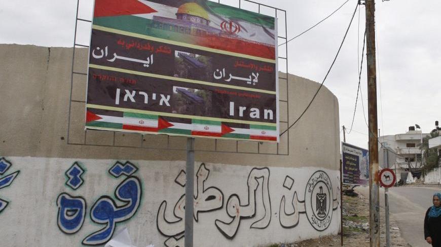 A Palestinian woman walks next to a banner that reads "Thanks and gratitude to Iran" in Gaza City November 27, 2012. Senior Hamas leader Mahmoud al-Zahar showed how fragile the ceasefire between Israel and Palestinians remained, with defiant remarks to reporters recently of how the Islamists would go on smuggling in weapons "by all possible means", including via Israel's arch-foe Iran. REUTERS/Ahmed Zakot (GAZA - Tags: CIVIL UNREST CONFLICT)