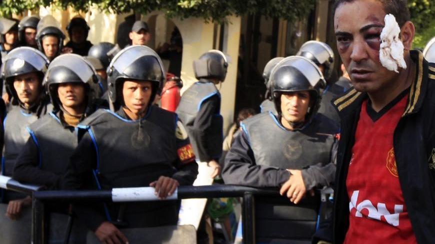 A protester who was injured during overnight clashes between supporters and opponents of Egyptian President Mohamed Mursi, is detained by the Republican Guard in front of the presidential palace in Cairo, December 6, 2012. Egypt's Republican Guard restored order around the presidential palace on Thursday after fierce overnight clashes killed seven people, but passions ran high in a struggle over the country's future. REUTERS/Mohamed Abd El Ghany (EGYPT - Tags: POLITICS CIVIL UNREST)