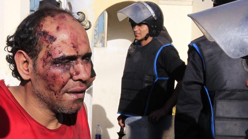 A protester who was injured during overnight clashes between supporters and opponents of Egyptian President Mohamed Mursi, is detained by the Republican Guard in front of the presidential palace in Cairo, December 6, 2012. Egypt's Republican Guard restored order around the presidential palace on Thursday after fierce overnight clashes killed seven people, but passions ran high in a struggle over the country's future. REUTERS/Mohamed Abd El Ghany (EGYPT - Tags: POLITICS CIVIL UNREST)